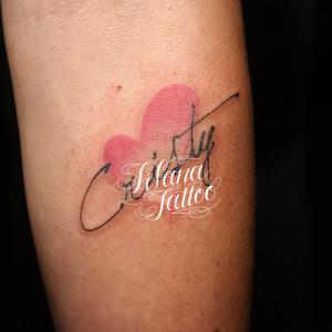 ハートに手書き風の文字のタトゥー