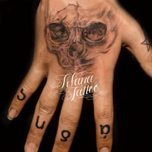 スカルと文字のタトゥー