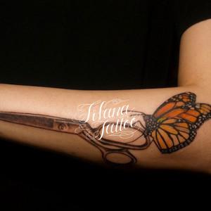 ハサミにとまった蝶のタトゥー