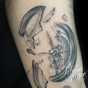 割れたコンパスのタトゥー