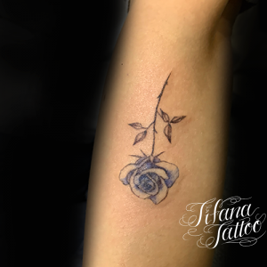 淡い青色の薔薇のタトゥー