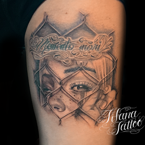 金網からのぞくクラウンガールのタトゥー